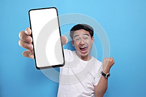 Asian man looking to camera, smiling and showing empty blank white copy space phone mock up template