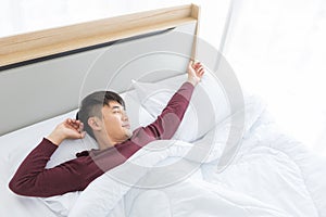 Asian man lying on bed, he slept deep in bedroom