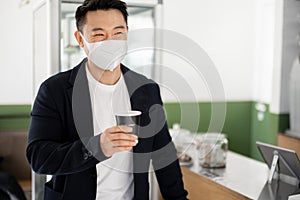 Asian man in medical with coffee going in store