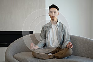 Asian man meditates in Lotus pose breathing deep and slowly