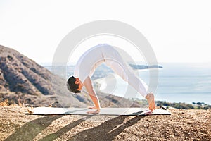 Asian man meditates in yoga position on high