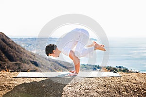 Asian man meditates in yoga position on high