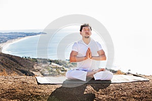 Asian man meditates in yoga position on high