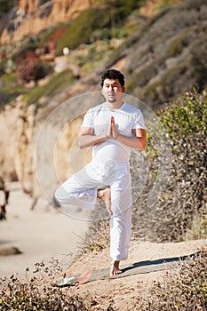 Asian man meditates in yoga position on high