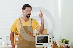 Asian man with mustaches Dressed in an apron overalls, held up forefinger, which was fanned with bandaged bandage. After injuring