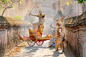 Asian man with old Thai traditional cloth hold weapon and stand and action of dance on traditional chariot also hold weapon action