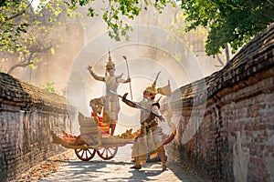 Asian man with old Thai traditional cloth hold weapon and stand and action of dance on traditional chariot also hold weapon action