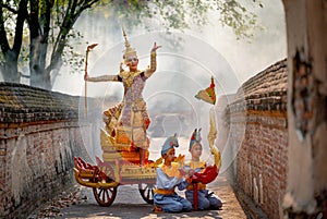 Asian man with old Thai traditional cloth hold weapon and stand and action of dance on traditional chariot also hold weapon stay