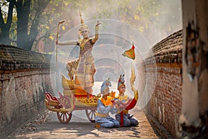 Asian man with old Thai traditional cloth hold weapon and stand and action of dance on traditional chariot also hold weapon stay