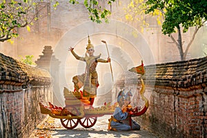 Asian man with old Thai traditional cloth hold weapon and stand and action of dance on traditional chariot also hold weapon stay