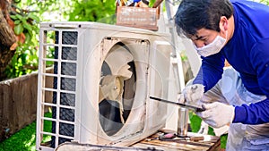 Asian man online learning and repair air conditioner at home. Social distancing