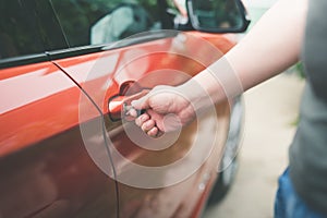 Asian man opening a car with key