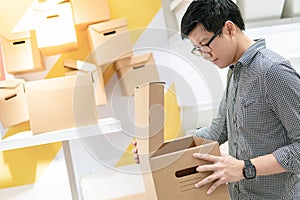 Asian man opening cardboard box package