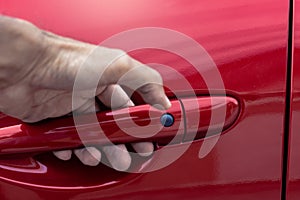 Asian man opens red car door with smart keyless For automotive or transportation image