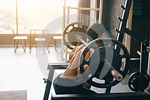 Asian man performing barbell squats at the indoor gym.