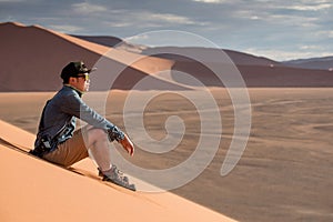 Asiático hombre fotógrafo sobre el arena duna 
