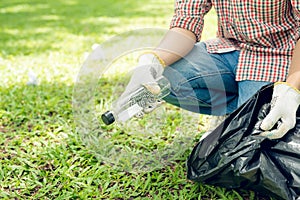 Asian man picking up plastic household waste in park