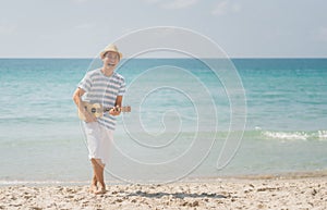 Asian man playing a ukulele and singing with enjoy on a tropical beach, Live life happily on holidays