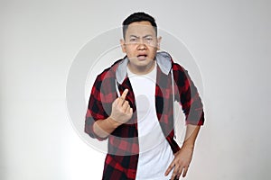 Asian man pointing himself with unhappy displeased expression as if he confused to be accused and asking who? me