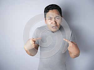 Asian Man Pointing Himself with Unhappy Expression as if he confused to be accused