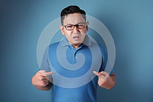 Asian Man Pointing Himself with Unhappy Expression as if he confused to be accused