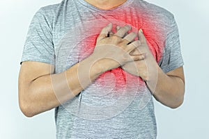 asian man pressing chest with painful expression. Severe heartache, having a heart attack or painful cramps, heart disease