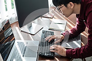 Asian man programmer looking on screen laptop to typing code data with keyboard about website and applications