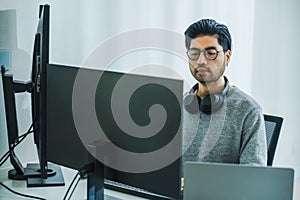 Asian man prompt engineer develop coding app with software data sitting in front of computer monitor at office