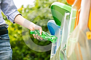 Asian man put plastic bottle into bin.