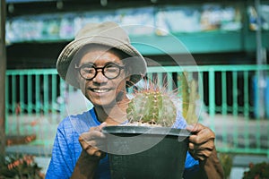 Asian man raising melocactus in planting pot