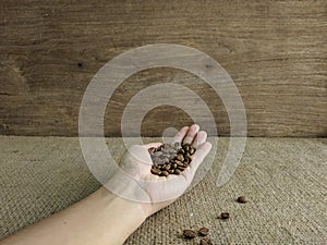 Asian man`s hands holding coffee beans.