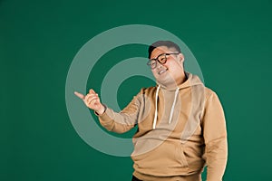 Asian man's portrait isolated over green studio background with copyspace