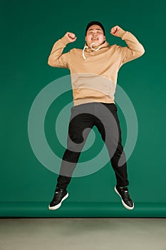 Asian man's portrait isolated over green studio background with copyspace