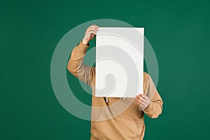 Asian man's portrait isolated over green studio background with copyspace