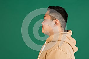 Asian man& x27;s portrait isolated over green studio background with copyspace