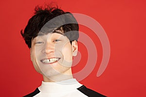 Asian man's portrait isolated over red studio background with copyspace