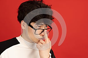 Asian man's portrait isolated over red studio background with copyspace