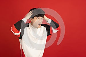 Asian man's portrait isolated over red studio background with copyspace