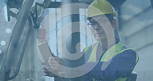 Asian man in safety gear operates machinery at an industrial site