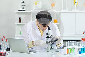Asian man scientist use microscope Biotechnology, chemistry, science, experiments and healthcare in the laboratory. Concept
