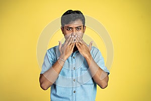 Asian man serious covering mouth with two hands in isolated