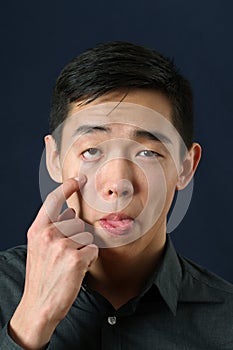 Asian man showing his eyelid and tongue photo