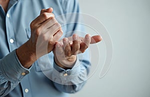 Asian man shows hand muscle rigidity, finger flexion. Wrist joint problems, Dupuytren contracture signs. Nerve damage arthritis photo