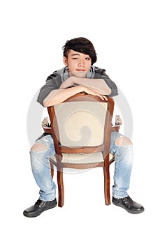 Asian man sitting backwards on chair.