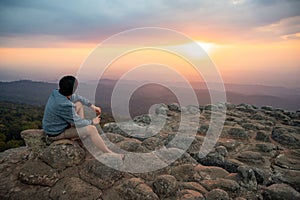 Asian man sitting on Nodule rock field enjoy looking sunset photo