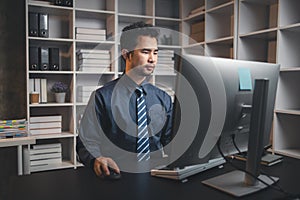 Asian man sitting in the office working overtime in the middle of the night, employee working overtime to get work done on time.