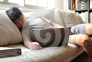 Asian man sleeping while working form home on sofa