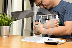 Asian man smiling and hugging a dream home and calculate to buy a house dreaming at his future,