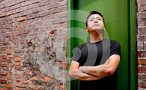 Asian man stand against a old door and lonely