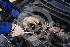 Asian man standing in front of inspection vehicle and inspecting machinery Problems in the car engine in the house and found probl